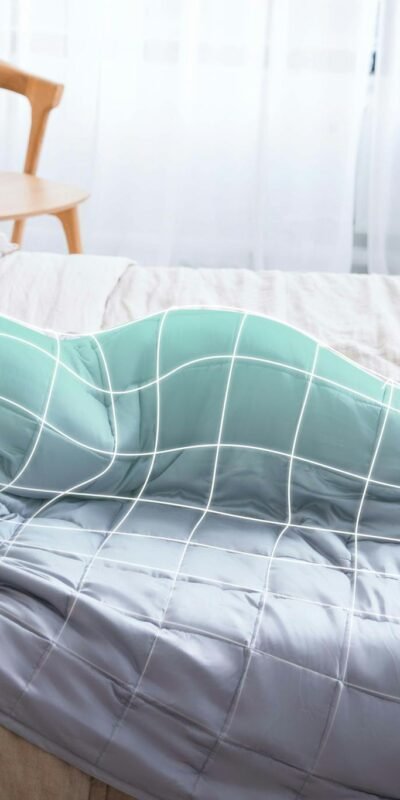 Relaxing scene of a woman peacefully sleeping under a cozy weighted blanket in a serene bedroom.